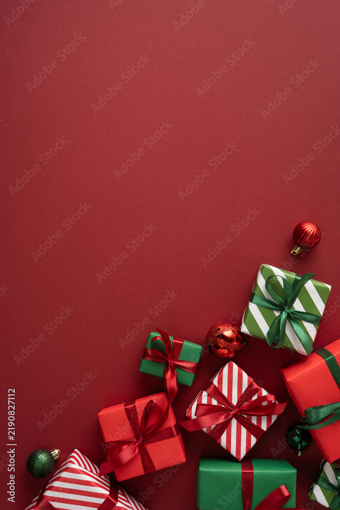 Naklejka premium Merry Christmas red vertical background with wrapped presents and ribbons for a happy New Year