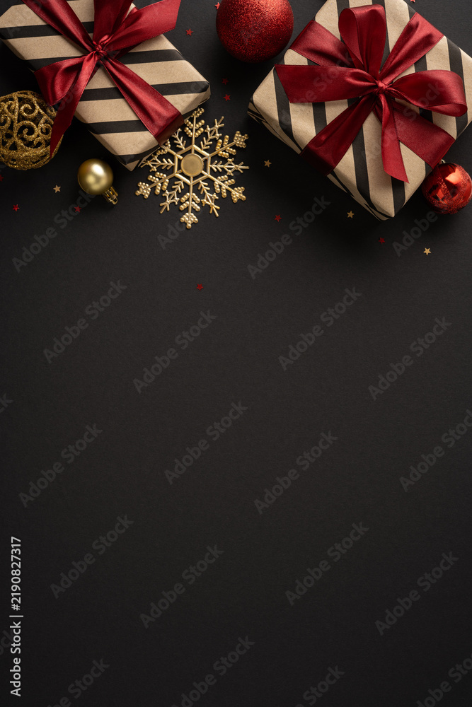 Obraz premium Elegant Christmas gift vertical composition with red ribbon, gold ornaments and Merry Christmas Happy New Year message