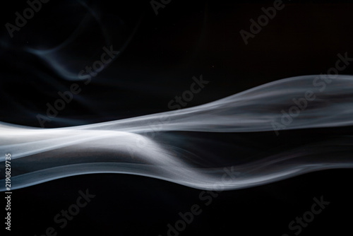 Cuadro en lienzo Swirling white smoke against a black background displaying smooth curves and flo