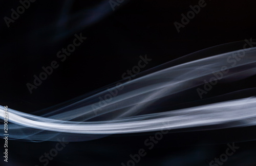 Cuadro en lienzo Swirling white smoke against a black background displaying smooth curves and flo