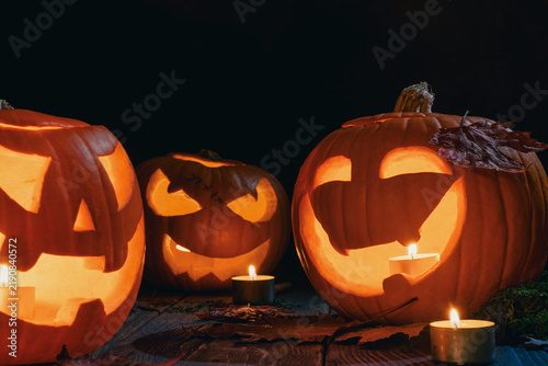 Quadro su tela Lit jack o lantern pumpkins and candles create warm autumn night display with ca