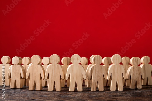 Wooden people figures arranged as a population, customers, or a group of employees.