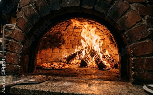 A fresh pizza baking inside a traditional brick oven