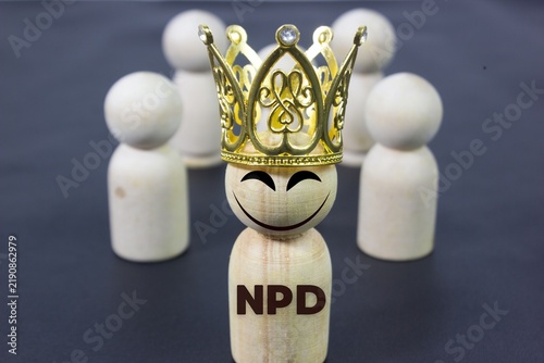 Foto Conceptual peg doll representing a powerful person wearing a crown with NPD text and an evil smile, symbolizing narcissism, manipulation, toxic leadership, ego, authority, and psychological behavior