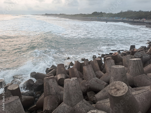 Concrete tetrapod breakwater barrier protecting coast from sea waves	