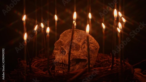 Human skull and black magic candles spirituality setup. Mystic and occult energy chemistry and witch craft background. Textured clay skull witchery for Halloween.