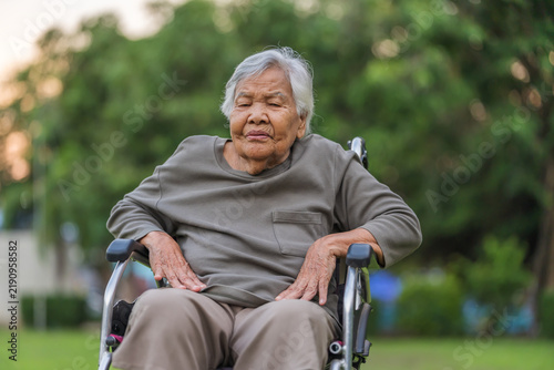 Bild auf Leinwand senior woman suffering from lower back pain in wheelchair at park