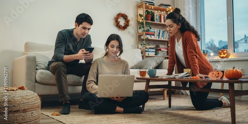 Three friends relaxing together at home with a laptop and phone in a cozy living room, happy halloween, halloween celebration theme