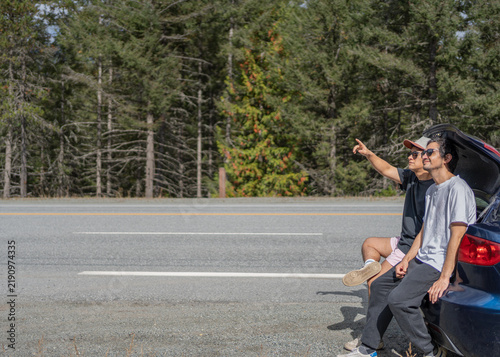 Two friends taking a break from their road trip