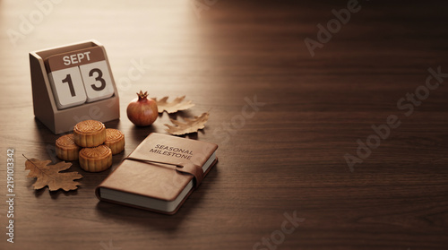 Calendar showing September thirteenth sits next to mooncakes and a leather notebook on a table.