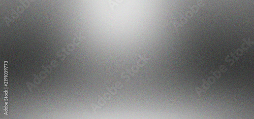Brushed silver metal texture with soft overhead spotlight. Metallic aluminum background with subtle grain and gradient lighting. Industrial steel surface for product display and tech design.