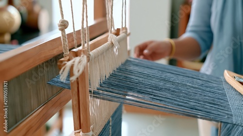Obraz na płótnie Persons hands operating a wooden loom with blue threads.