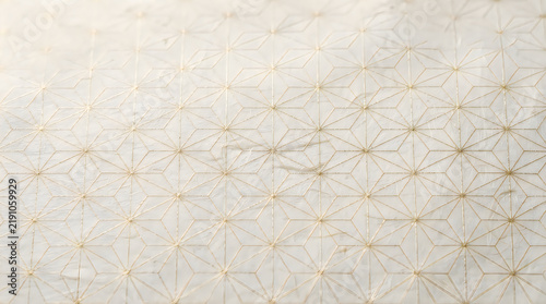 Geometric star pattern with gold lines on textured paper
