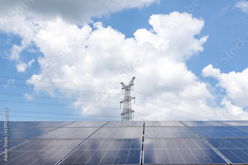 Canvastavla solar panels and electricity pylon under blue sky with clouds