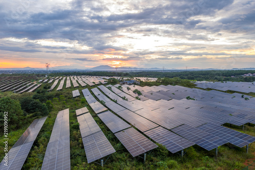 фотографія rows of solar panels on green hillside generating clean energy