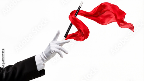 Magician Hand in White Glove Performing Trick with Wand and Flowing Red Silk Ribbon Isolated on White Background