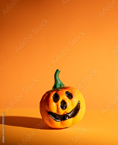 Vertical single jack-o-lantern on orange background with long shadow and copy space for minimal Halloween poster or product mockup