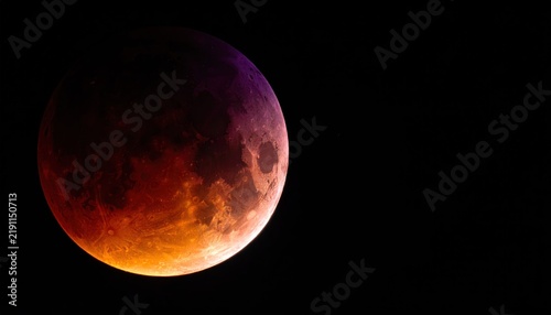 Total lunar eclipse showing blood moon in sky.