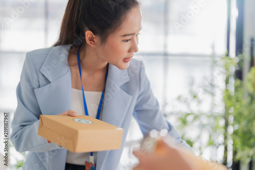 фотографія Enthusiastic Asian businesswoman presenting recyclable packaging product to client during sales consultation, demonstrating persuasive communication, eco marketing, and sustainable entrepreneurship
