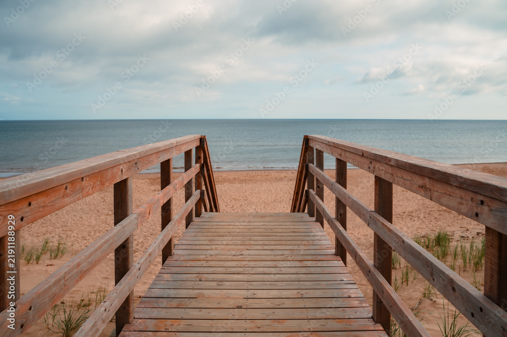 Obraz premium Wooden staircase leading down to a sandy beach in PEI