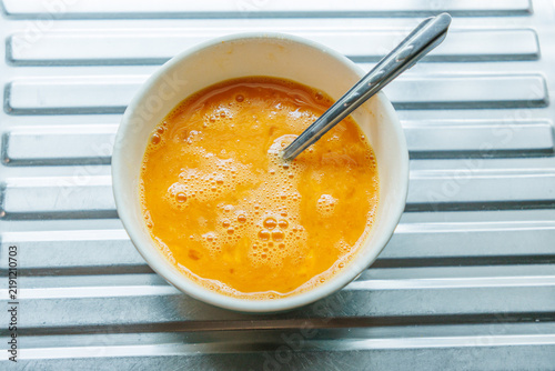 Cracking a raw egg into a bowl, preparing to fry an egg.