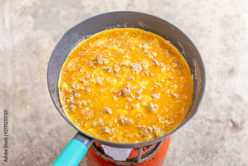 Fresh and appetizing Thai-style omelet cooking in a frying pan.