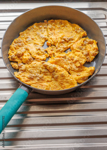 Fresh and appetizing Thai-style omelet cooking in a frying pan.