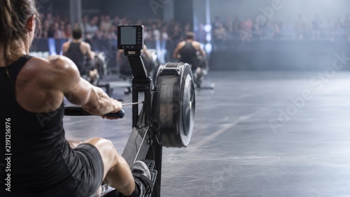 Athlete doing indoor rowing during functional fitness race competition