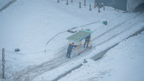 фотографія During the harsh winter months, a team of diligent workers busily constructs a sturdy shelter amidst a picturesque snowy landscape
