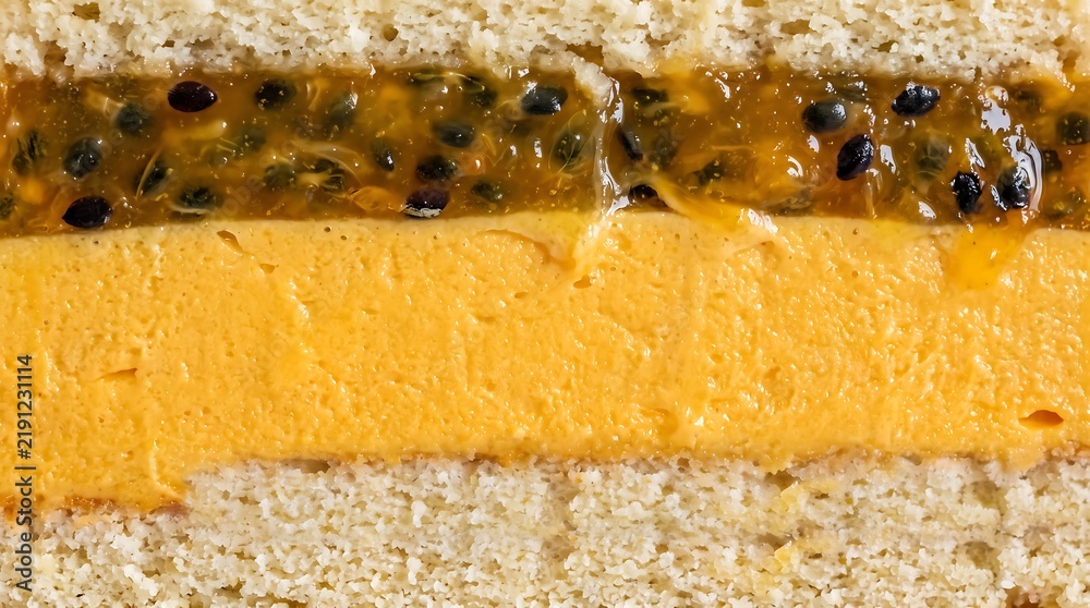 Obraz premium Macro shot cross section of passion fruit mousse cake with seed jam and sponge layers