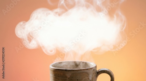 Ceramic Coffee Cup with Billowing Cloud of Steam on Warm Orange Backdrop