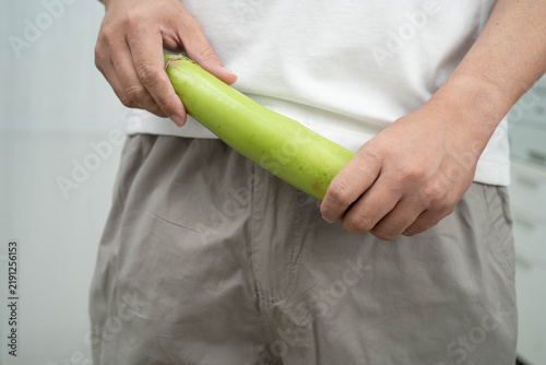 Fotografía Male stands holding a banana, penis health.