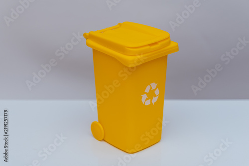 Quadro su tela Yellow recycling bin isolated on clean minimal studio background