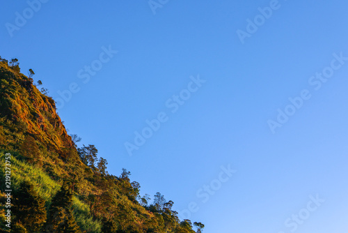 Fotografía Rugged hillside slopes upward under clear, vibrant blue sky