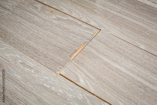 Foto Damaged laminate flooring with lifted boards, chipped edges and visible gaps on