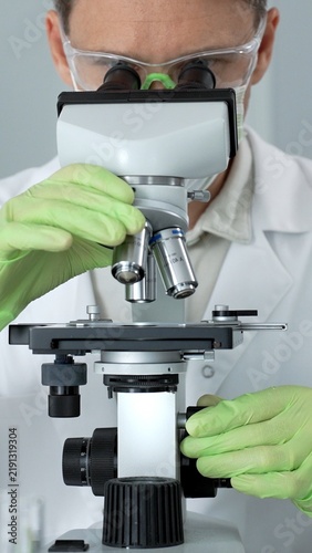 Cuadro en lienzo Scientist in personal protective equipment working with a professional microscop