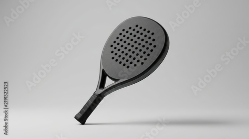 Clean shot of a black padel racket mockup, subtly angled on a smooth gray background, perfect for product advertising and minimalist sports equipment branding.