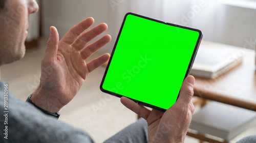 Man Hand Holding a Modern Smartphone in a Living Room
