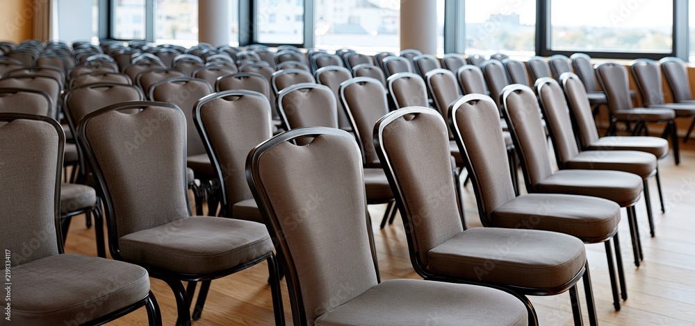 Fototapeta premium A bright, modern conference room featuring rows of chairs arranged for a corporate seminar in a professional setting.