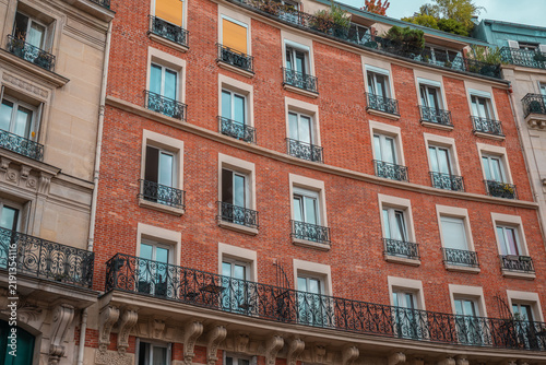 Fotografía Parisian residential building facade featuring brick walls, classic balconies, a