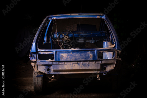 Stripped blue car body chassis frame from rear view during total restoration or salvage project