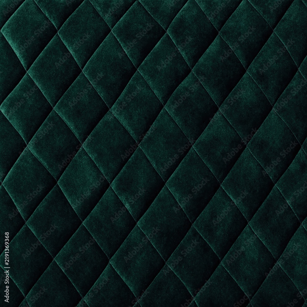 Fototapeta premium A close-up texture of dark green quilted velvet fabric featuring a classic diamond stitched pattern.