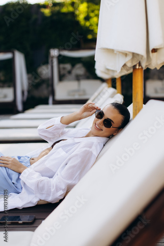 Canvastavla Young woman relaxing on a sun lounger during vacation