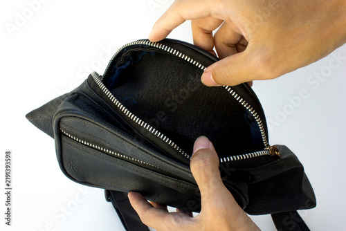 Hands opening empty black leather waist bag with zipper