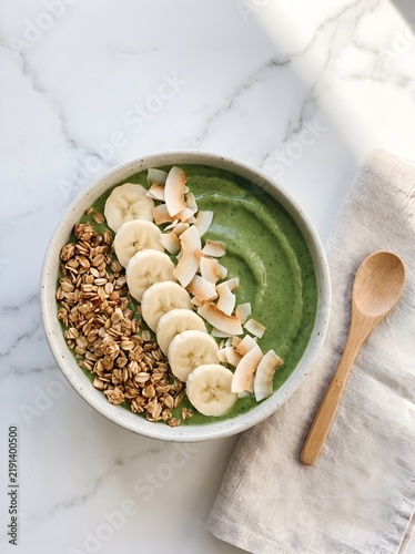 Green smoothie bowl with banana and granola toppings