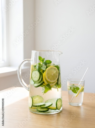 Glass pitcher of detox water with cucumber lemon and mint