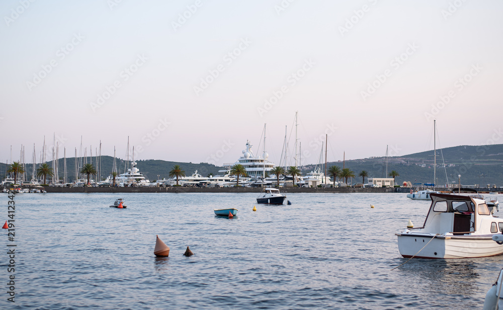 Obraz premium Yachts and boats are moored in a calm harbor at dusk
