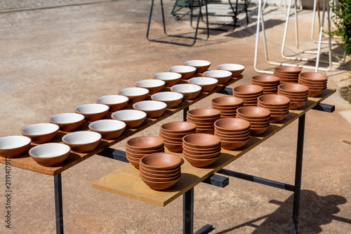 Foto Handcrafted clay bowls drying in outdoor pottery workshop