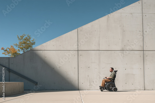 Wheelchair user encountering steep urban staircase accessibility barrier on street