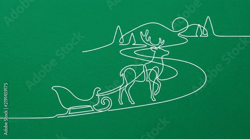 Continuous white line of reindeer sleigh on winding road through pines